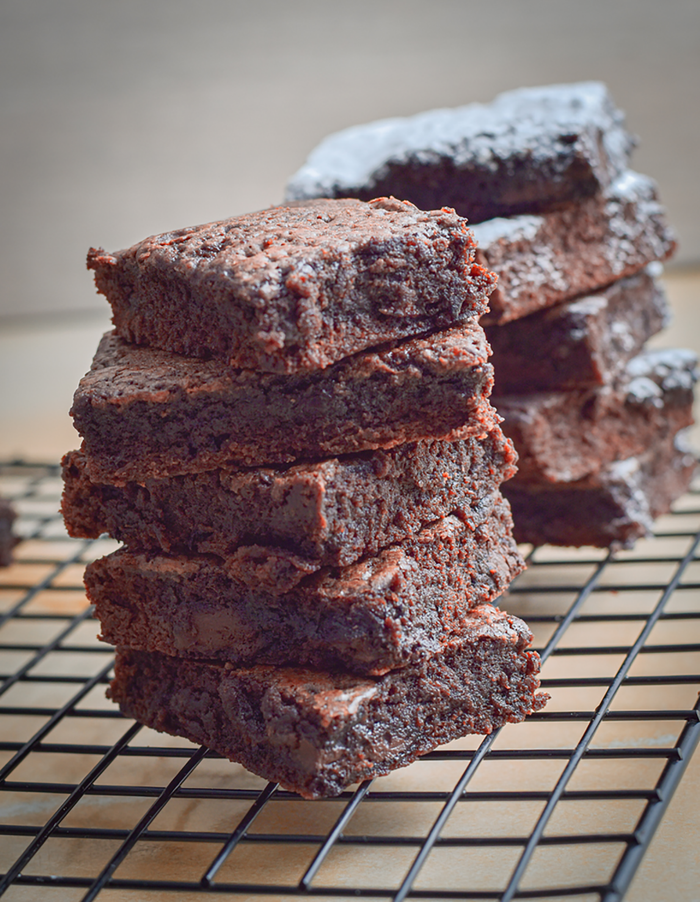 Freshly baked chocolate brownies stacked on a cooling rack, rich and tempting.