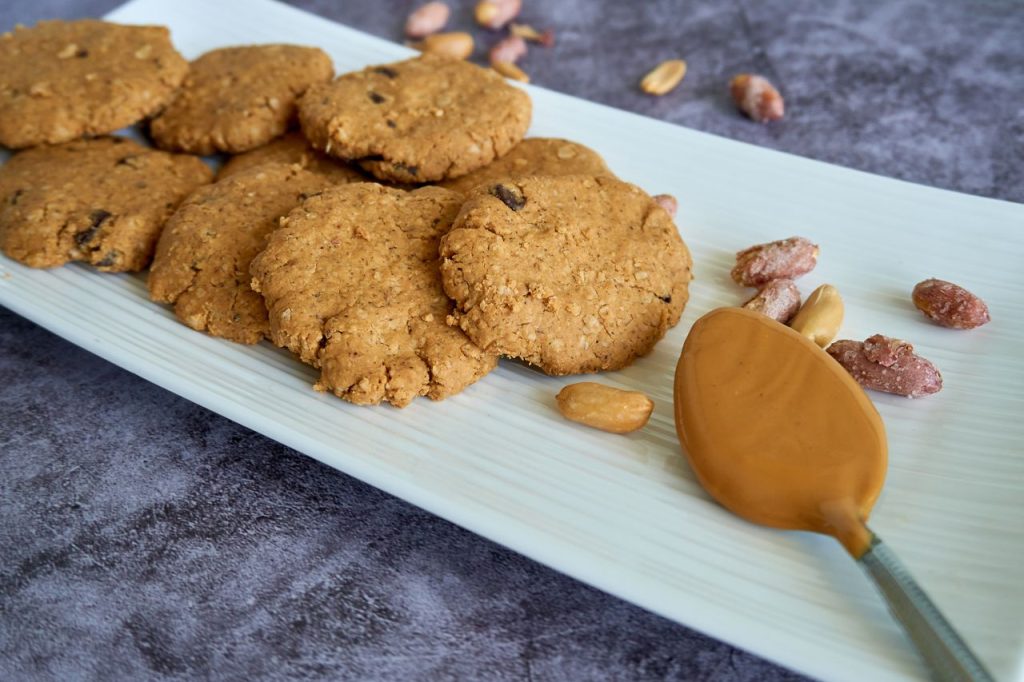 Close-up of tasty peanut butter cookies arranged on a white plate, perfect for food photography.